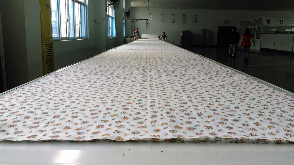 株式会社アストロ中国工場で柄入り不織布カバーを広げた画像