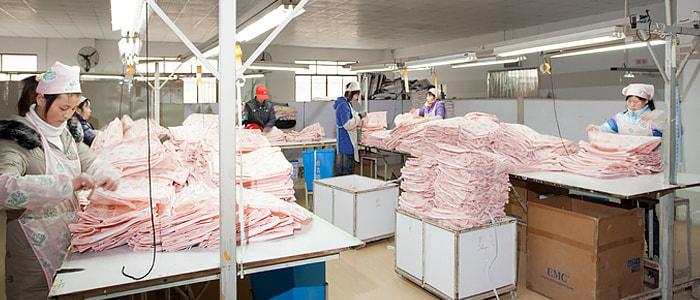 株式会社アストロ中国工場で縫製した不織布カバーを検品している画像